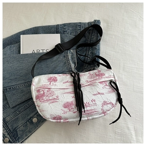 Detail of pink Toile de Jouy print on a pleated nylon crossbody bag with black straps