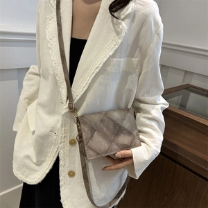 Borsa a tracolla trapuntata a rombi grigio marrone, abbinata a un blazer bianco