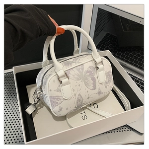 Macro shot of white pillow bag showing purple butterfly print and silver zipper detail
