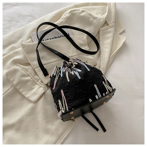 Close-up of black nylon bucket bag with wave embroidery and leather bottom detail