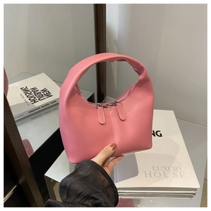 Close-up of pink minimalist crescent handbag featuring a dual zipper and stylish top handle