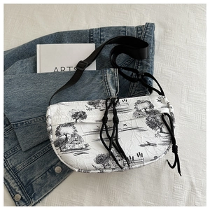 Detail of pleated crossbody bag featuring Toile de Jouy pattern and adjustable strap