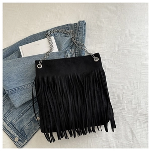 Détail du sac cabas en daim noir avec de longues franges et des bandoulières en chaîne