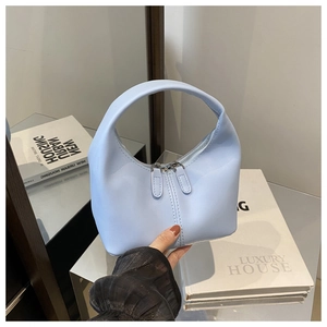 Detail of light blue semi-moon handbag with dual zippers and decorative stitching