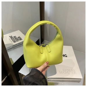 Detail of lime green hobo handbag with a circular handle and smooth PU leather texture