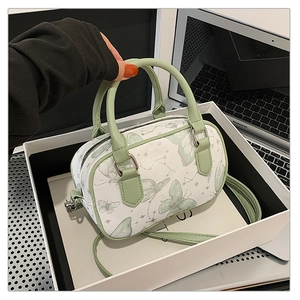 Detailed view of light green Boston bag with butterfly print and adjustable strap