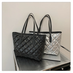 Détail de sacs fourre-tout matelassés en noir et argent avec motif à losanges