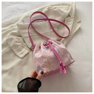 Detailed view of pink nylon bucket bag with F-letter texture and colorful embroidery