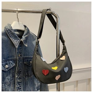 Detail of dark grey crescent shoulder bag with colorful 3D heart leather patches