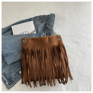 Détail du sac cabas en daim marron avec longues franges et bandoulière en chaîne