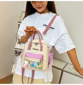 Dettaglio mini zaino in tela con tasca in PVC e pon pon colorati
