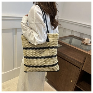 Détail du sac cabas en paille tressée avec rayures noires et fermeture éclair
