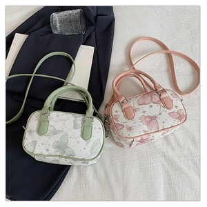 Detail of pink and mint green butterfly print mini bags with shoulder straps on fabric