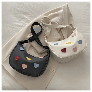 Macro shot of colorful heart-shaped leather patches on a minimalist hobo shoulder bag