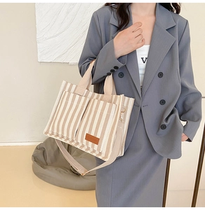 Detail view of striped canvas tote bag with reinforced handles and adjustable shoulder strap