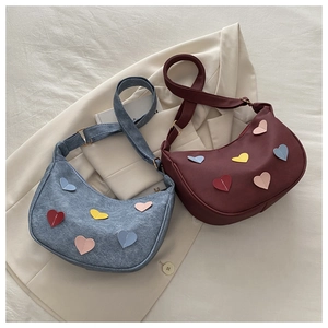 Close-up of stylish hobo shoulder bag featuring colorful heart-shaped leather patches