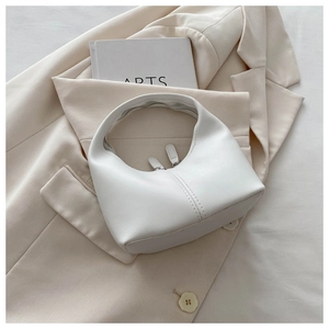 Top view of white half-moon handbag featuring detailed stitching and dual zipper closure