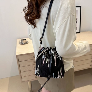 Chic black drawstring bucket bag with colorful embroidery and adjustable strap