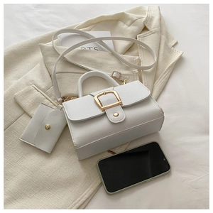 Détail du sac bandoulière blanc à motif litchi avec boucle dorée et mini pochette