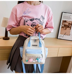 Dettaglio dello zaino in tela con tasca in PVC trasparente piena di pompon colorati