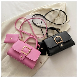 Détail de deux sacs à main en cuir texturé rose et noir avec des boucles dorées