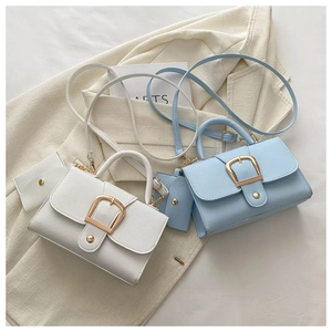 Détail de sacs bandoulière en blanc et bleu clair avec boucle en métal et pochette ronde