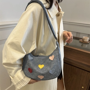 Gray denim crescent moon shoulder bag featuring colorful heart patches and zipper closure