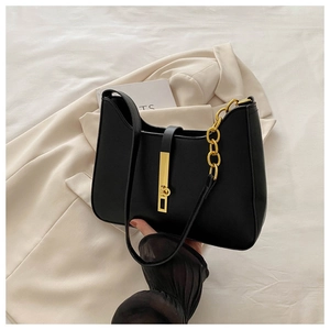 Detail of black faux leather shoulder bag featuring a sleek gold metal lock and chain strap