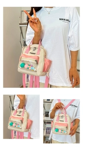 Dettaglio zaino in nylon bianco e rosa con tasca trasparente e palline di peluche colorate