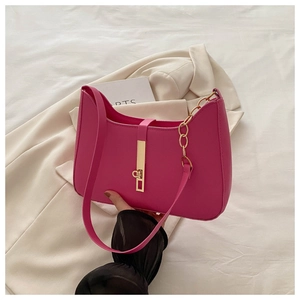 Detail of rose red leather underarm bag with gold lock buckle and chain on beige blazer