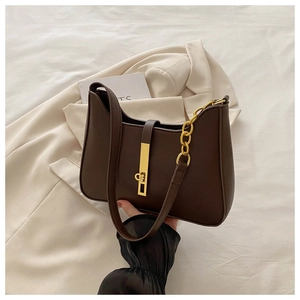 Detail of dark brown leather underarm bag featuring a gold buckle and chain strap