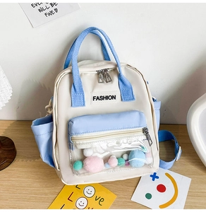 Dettaglio degli spallacci in nylon azzurro e tasca trasparente con pompon colorati