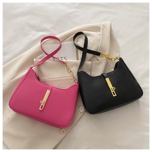 Detail view of stylish leather shoulder bags with gold piston locks in black and rose pink