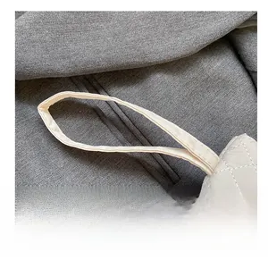 Detailed close-up of the white quilted rhombus stitching and durable handle strap
