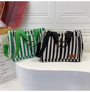 Detail of striped canvas tote bags featuring dual pockets and adjustable wide shoulder straps