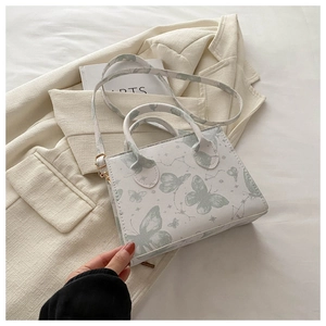 Detail of white butterfly and constellation print on crossbody bag with cross-grain texture