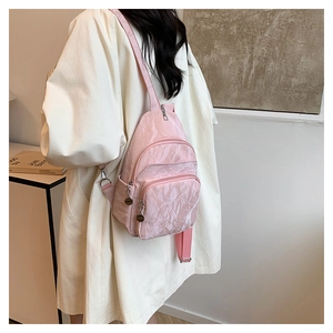 Sac bandoulière en nylon rose avec texture plissée et compartiments zippés multiples