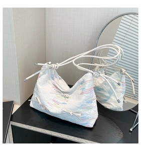 Detail of white seersucker bag with colorful wavy lines and small bow decorations