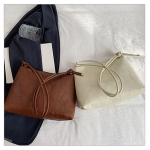 Detailed patchwork stitching on dark brown and cream white faux leather shoulder bags