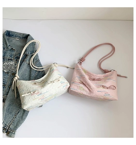 Detail of hobo bags featuring embossed textures, colorful embroidery and bow accents
