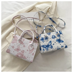 Detail of floral butterfly print on small square crossbody bag with textured leather