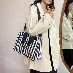 Striped canvas tote bag with leather tag, black top handles and adjustable shoulder strap