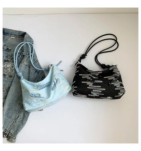 Detail of trendy tote bags with wave embroidery and bead knot handles on white background