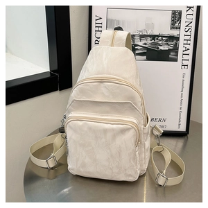 Détail du sac bandoulière blanc cassé avec tissu plissé et poches zippées pratiques