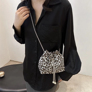 Borsa a secchiello leopardata con coulisse e catena d'argento indossata da modella