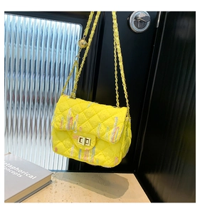 Detailed view of yellow quilted crossbody bag with colorful stitching and gold hardware