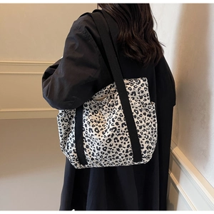 Detail of the leopard print canvas tote bag showing the zipper closure and shoulder strap