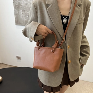 Brown litchi texture bucket bag with knot handle and adjustable strap for women