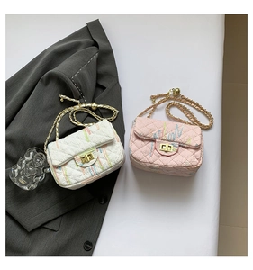 Close-up of quilted chain crossbody bags in pearl white and sakura pink with gold lock