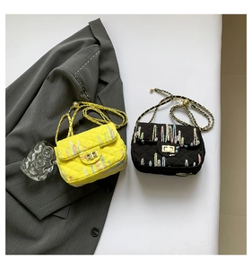 Detail of mini quilted crossbody bags in yellow and black with gold chain and twist lock
